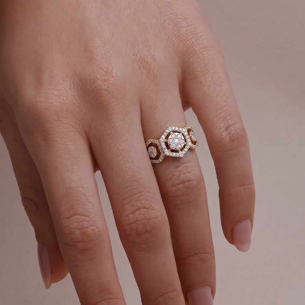 A close-up of a hand wearing a gold ring with diamond accents, set against a soft beige background.