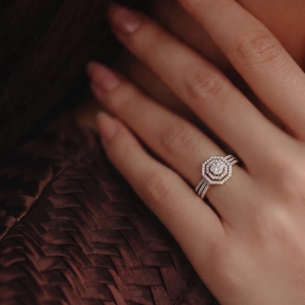 Close-up of a hand wearing a diamond ring on a textured brown surface