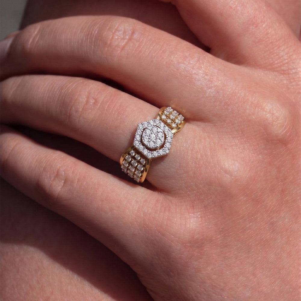 Gold ring with a center cluster and diamond accents on a person's finger.