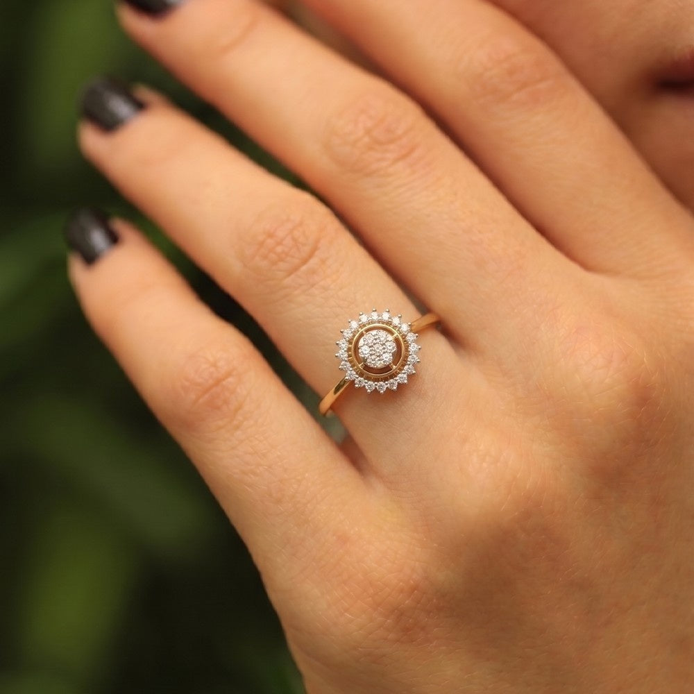 Gold ring with diamonds on a hand against a blurred green background