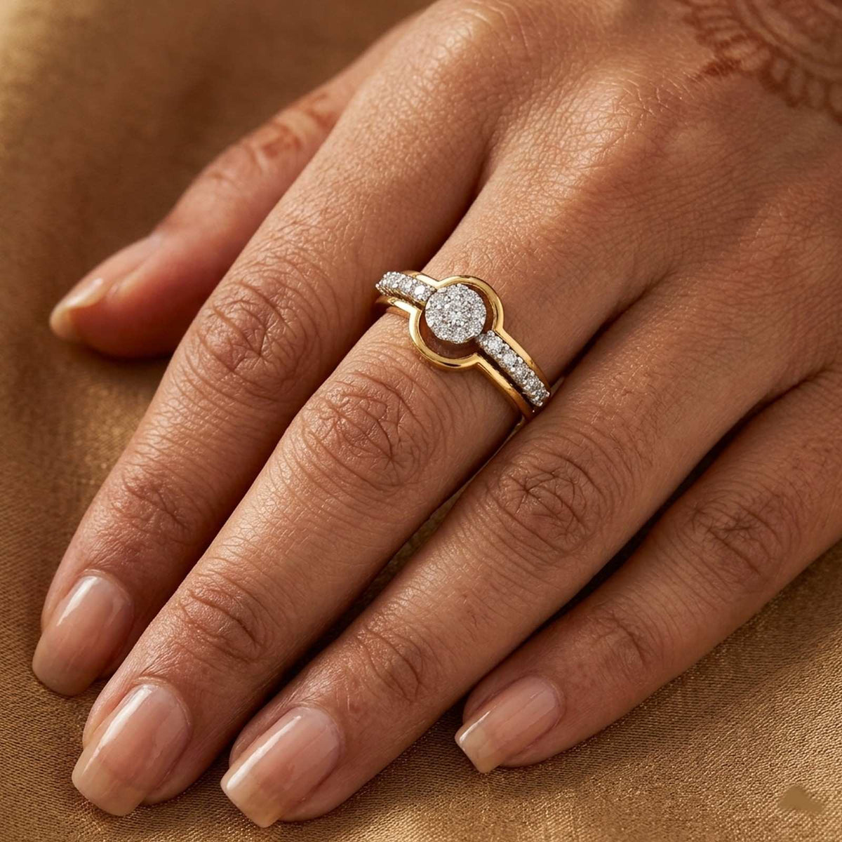 Gold ring with a diamond on a person's finger against a mustard background