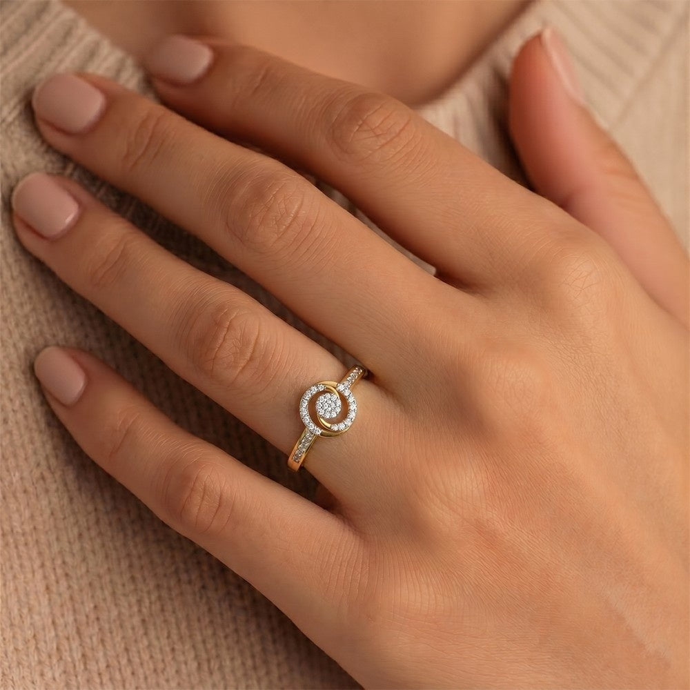 Close-up of a hand wearing a gold ring with a diamond on a beige background