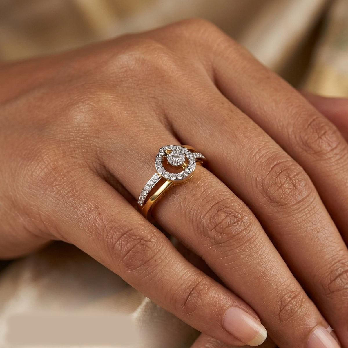 Gold ring with diamonds on a hand against a saree background