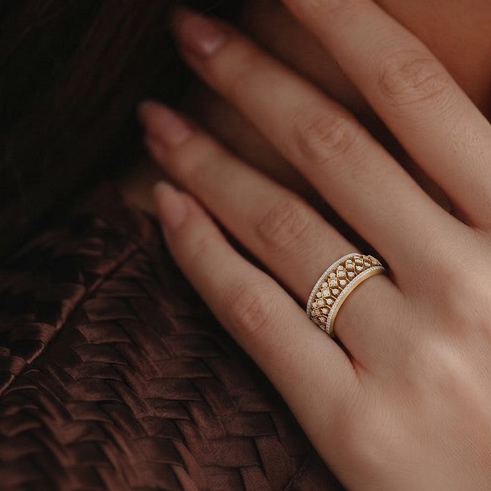 Close-up of a hand wearing a gold ring on a textured brown fabric background