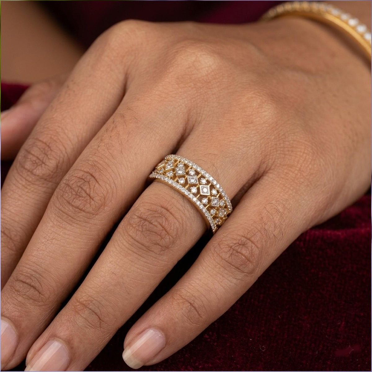 Close-up of a hand wearing a gold ring on a textured red fabric background