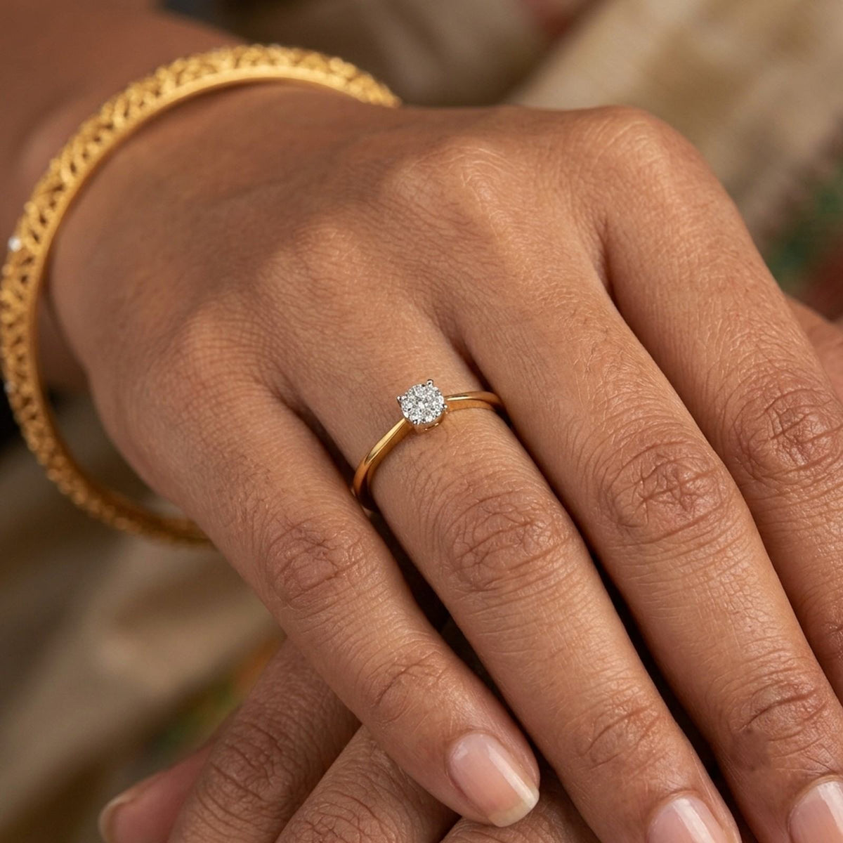 Gold ring with diamond accents on a person's finger against a neutral background