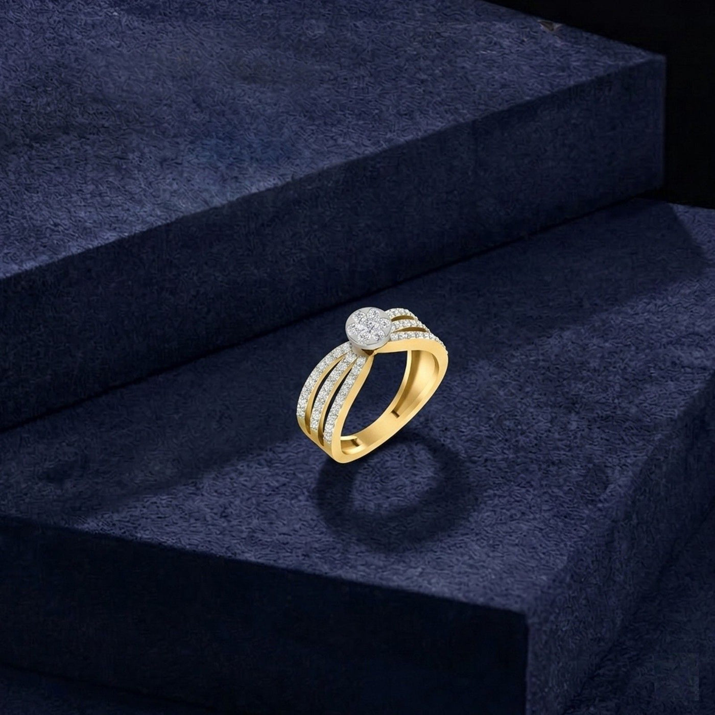 Gold ring with diamonds on a dark blue textured surface.