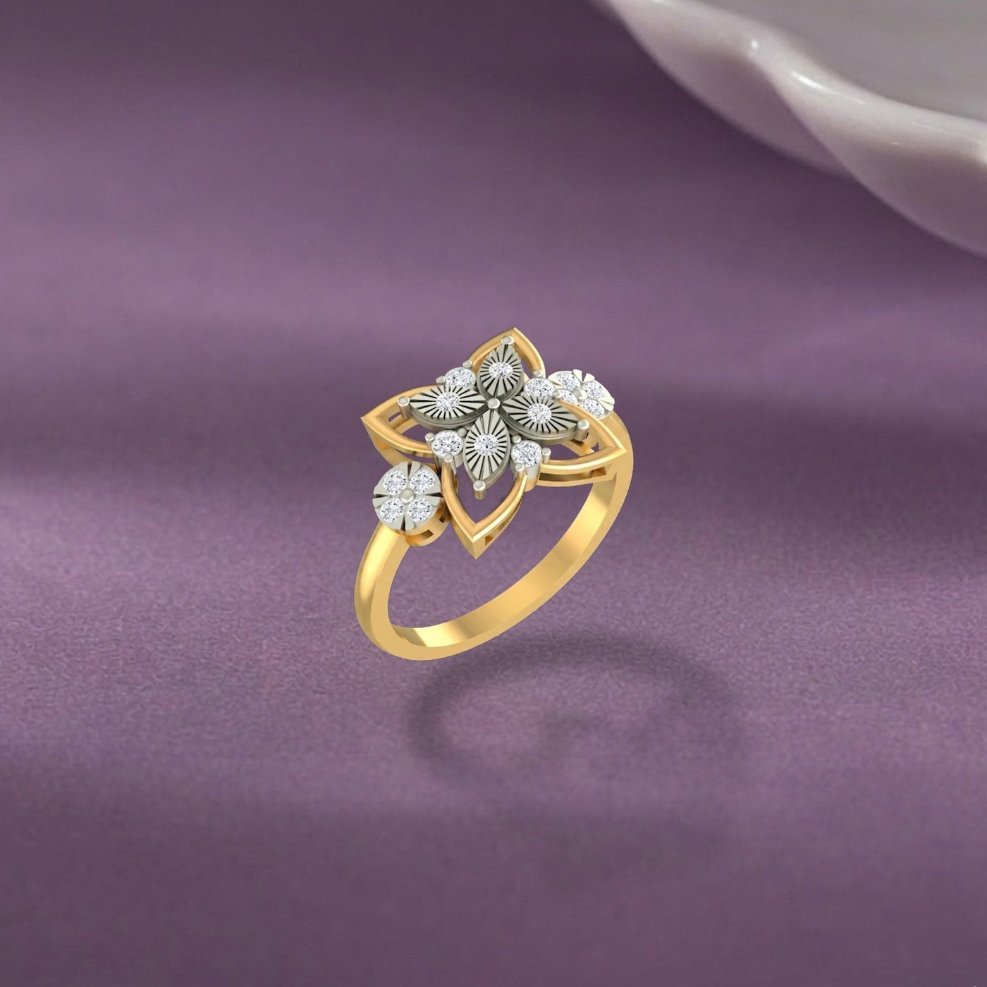 Gold ring with floral design on a purple fabric background.