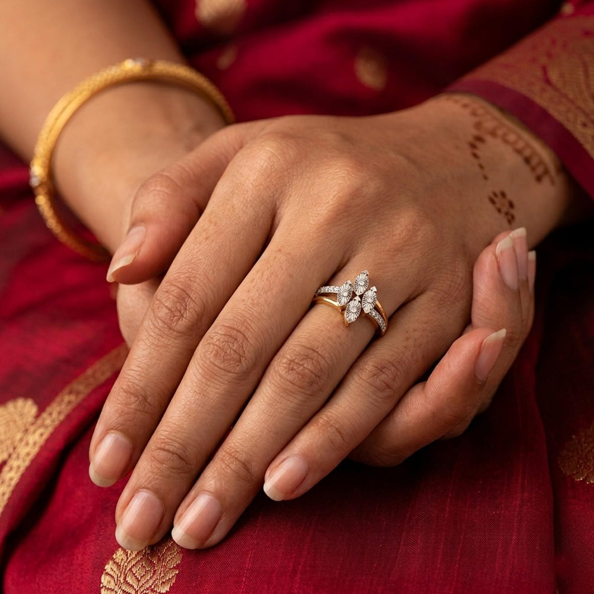 Gold and diamond ring with floral design diamonds on a hand