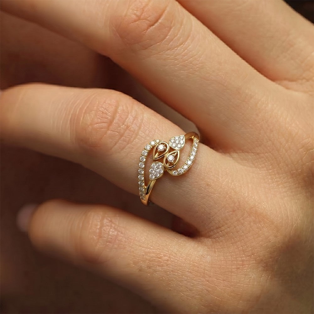 A gold  and diamond ring, worn on a person's finger.