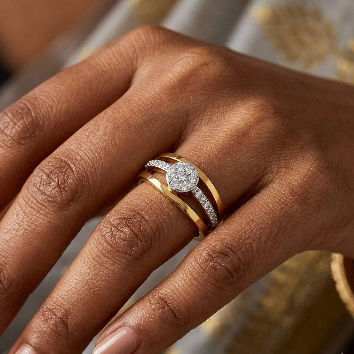 A close-up of a hand wearing a gold and diamond ring.