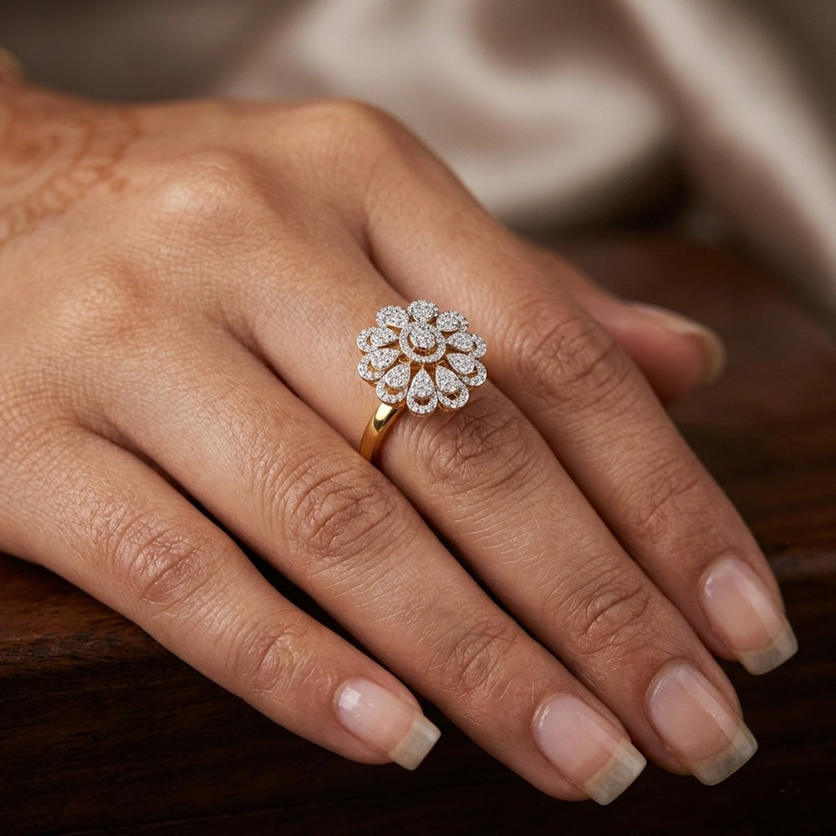 Close-up of a hand wearing a gold and diamond  ring with a blurred background