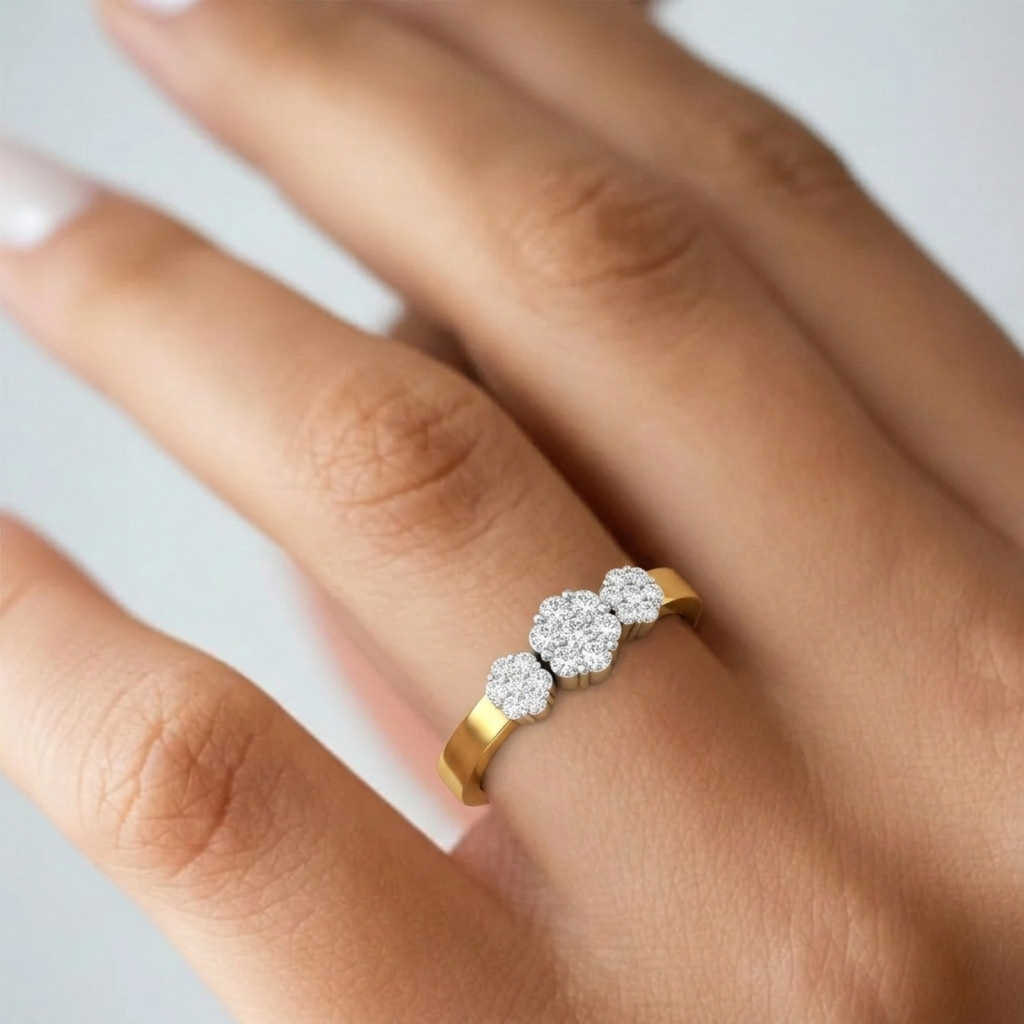 A close-up of a hand wearing a gold ring with three small round, set against a soft light gray background.
