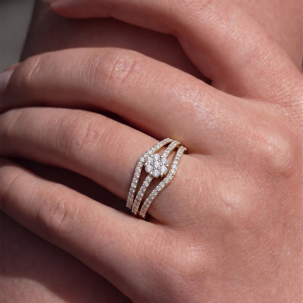 Close-up of a hand wearing a rose gold ring with a diamond on a neutral background.