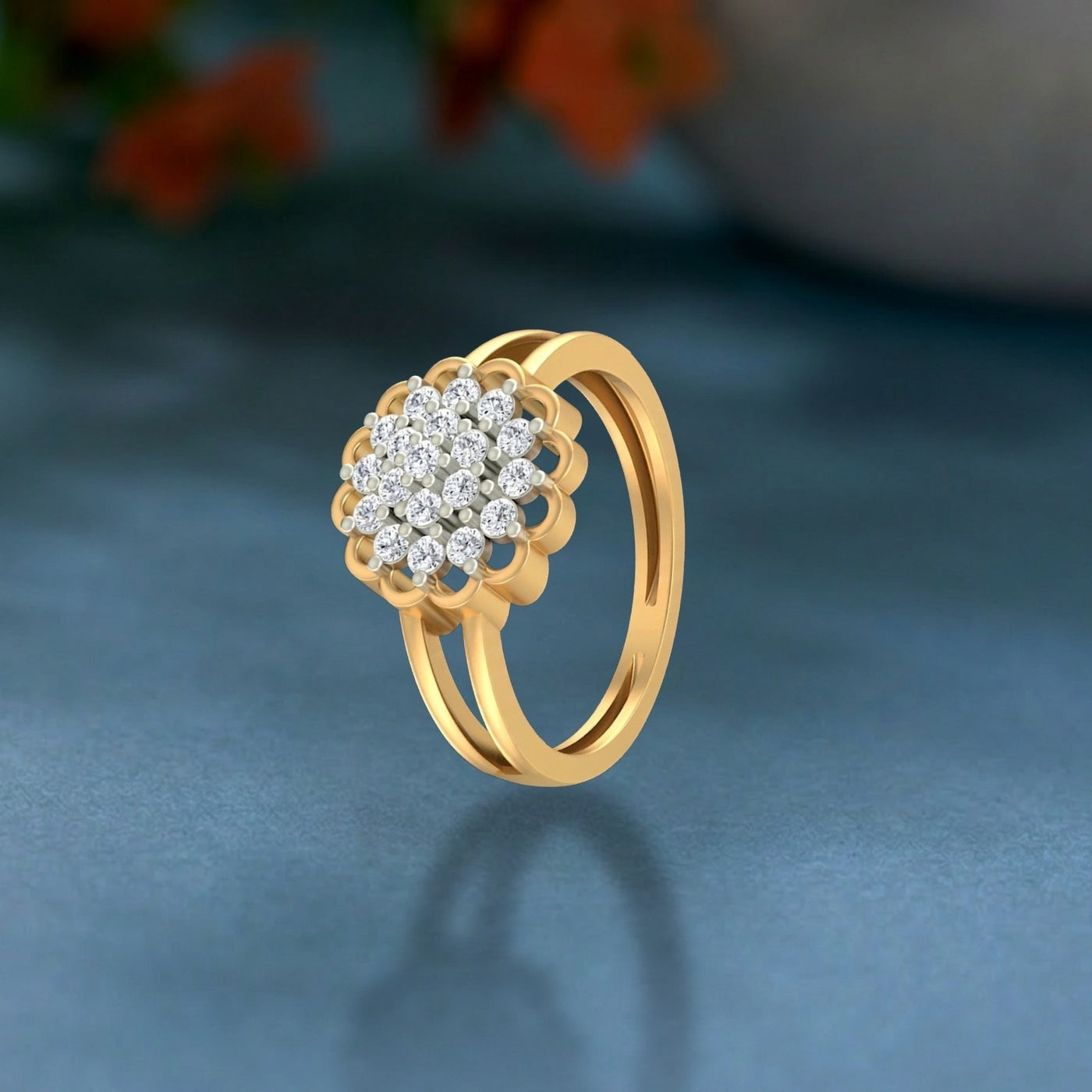 Gold ring with diamond flower design on a blue background