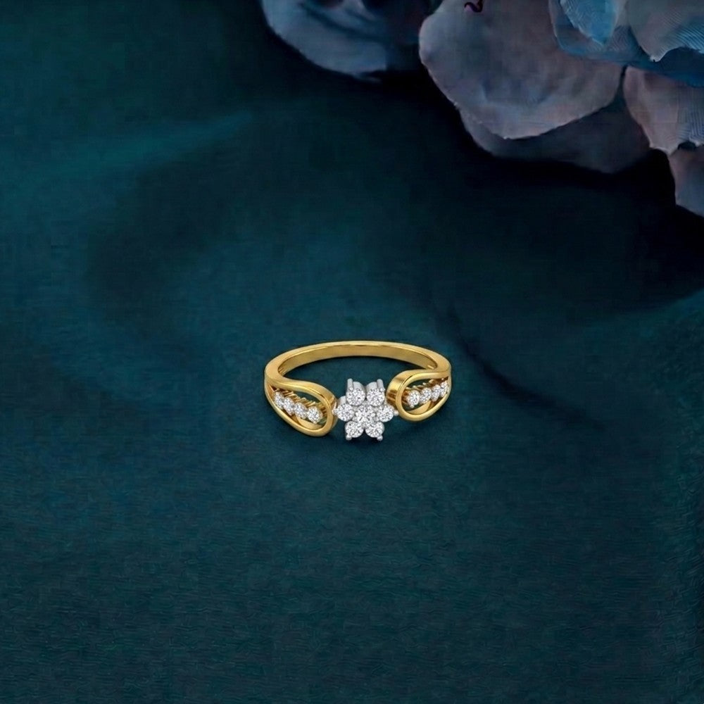 Gold ring with floral design on a dark green fabric background