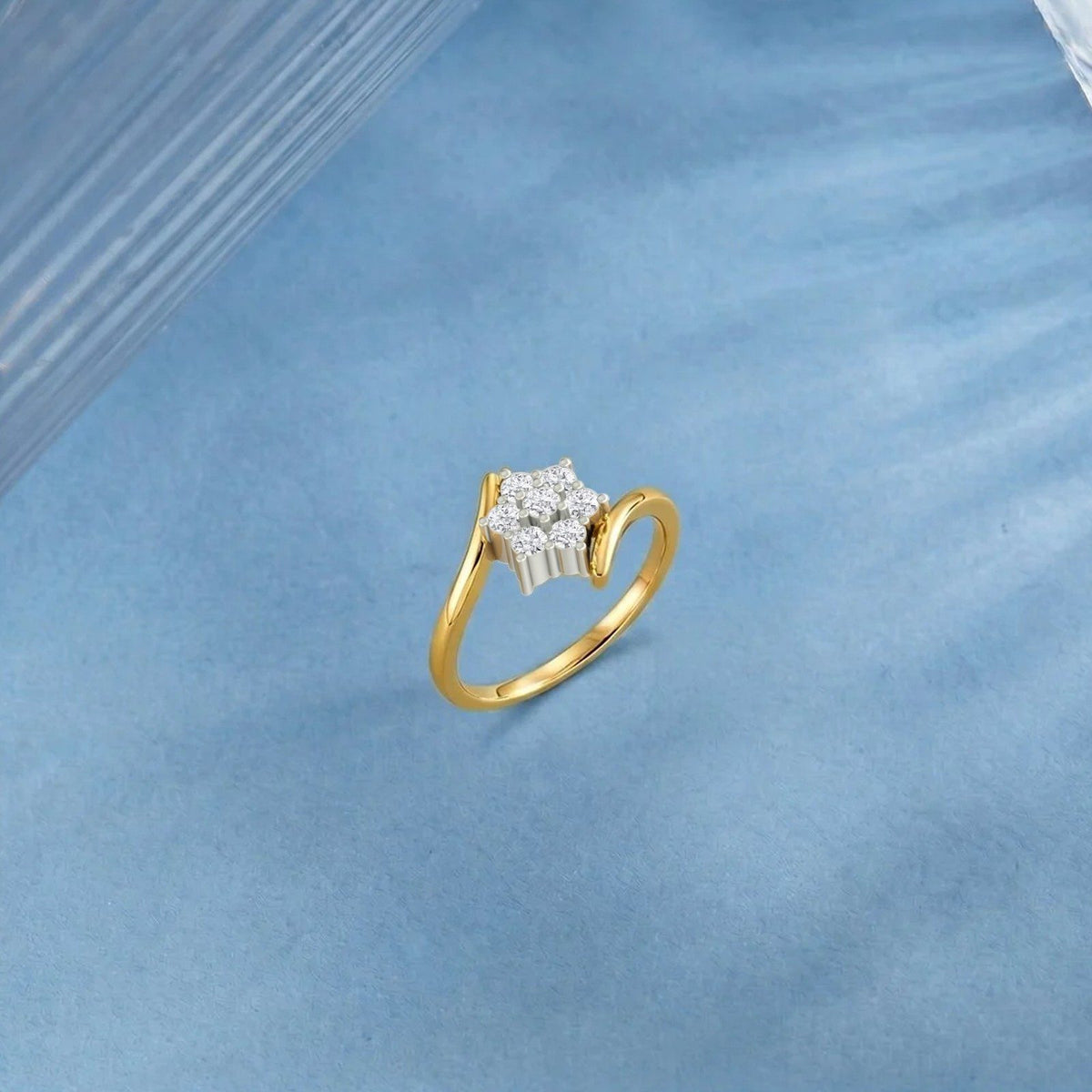 Gold ring with floral cluster diamond design on a blue fabric background