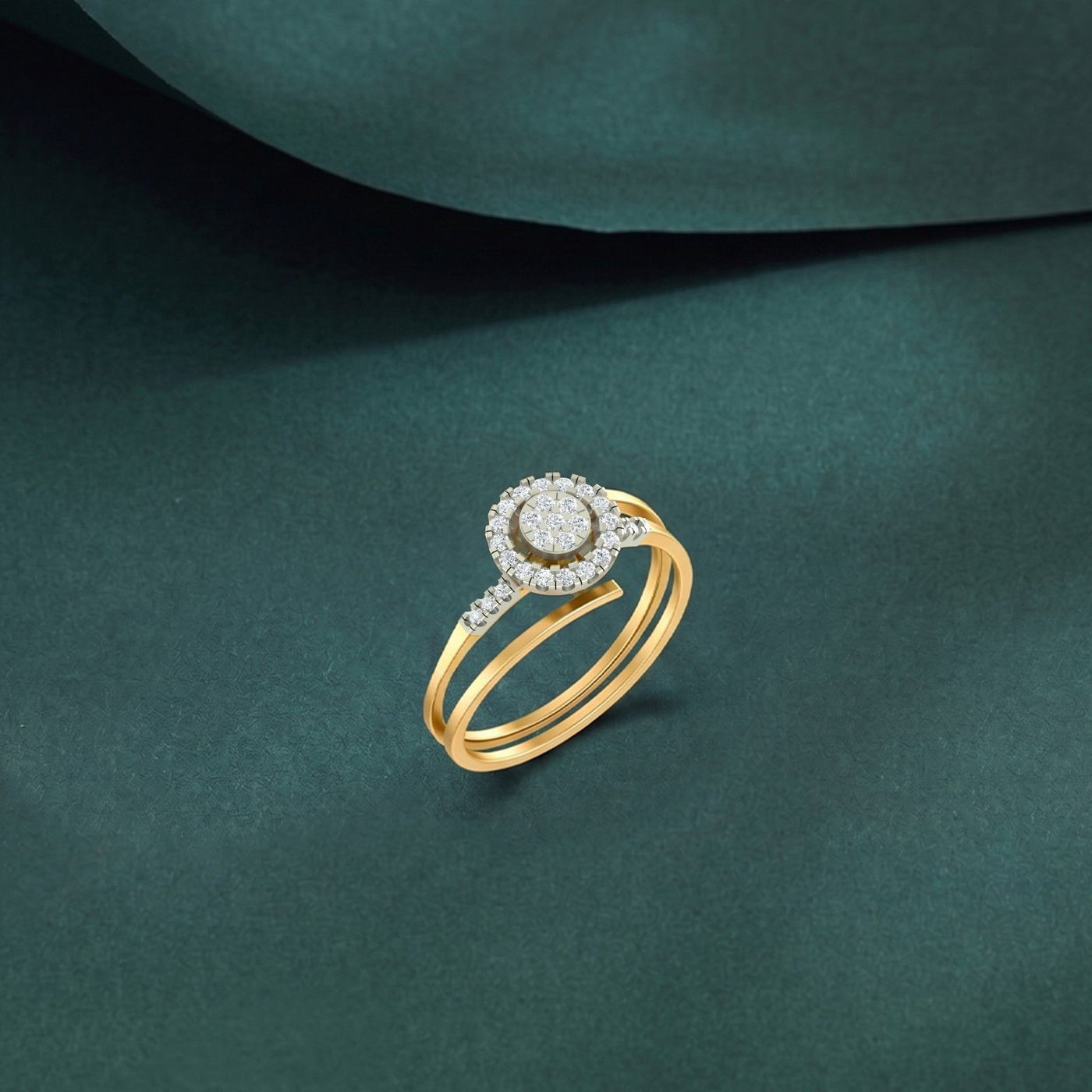 Gold and diamond with halo cluster setting ring on a teal surface.
