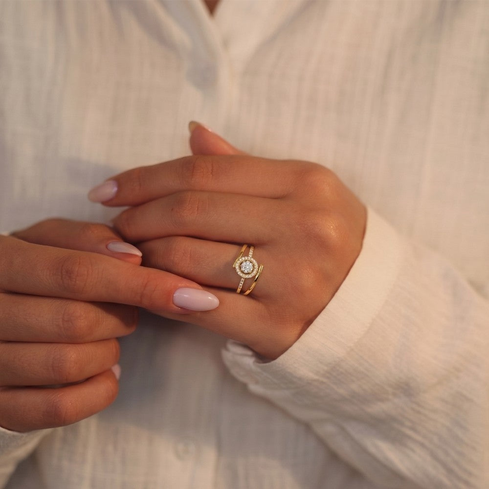 Close-up shot of a gold and diamond with halo cluster setting ring.