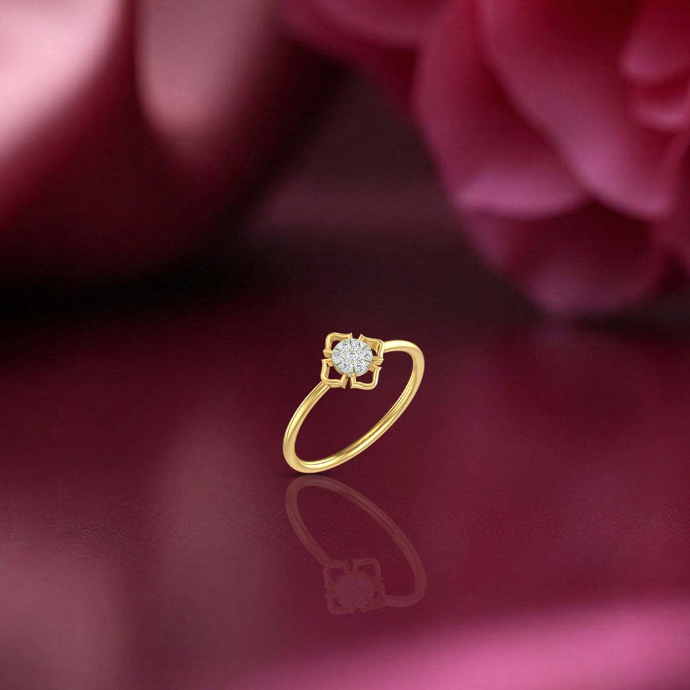 Gold and diamond with round-shaped cluster setting on a red reflective surface.