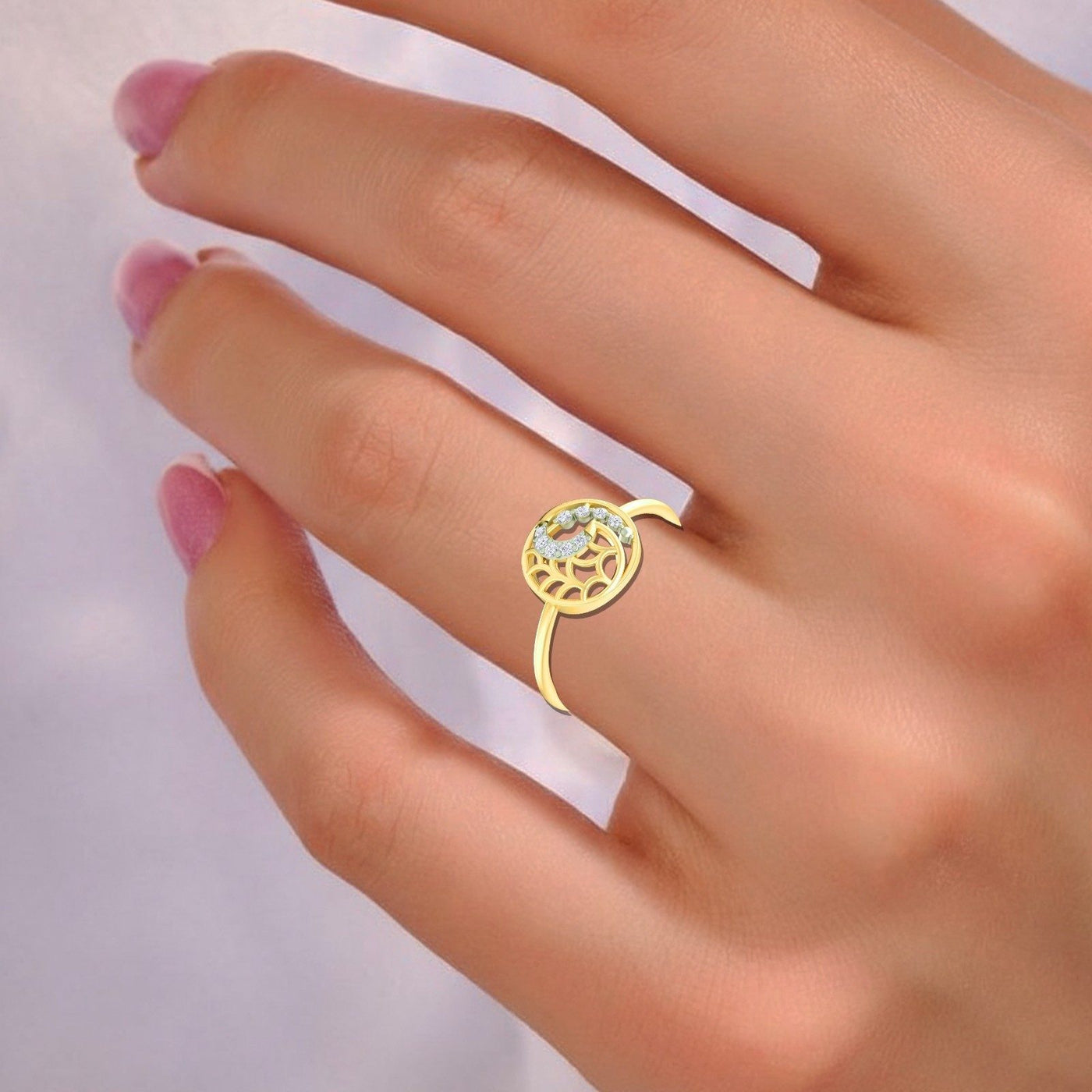 Gold ring with a decorative design on a hand against a light background