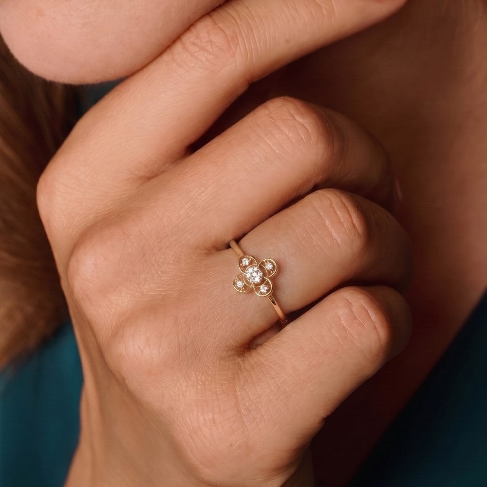 Close-up shot of a gold and diamond with floral design ring.
