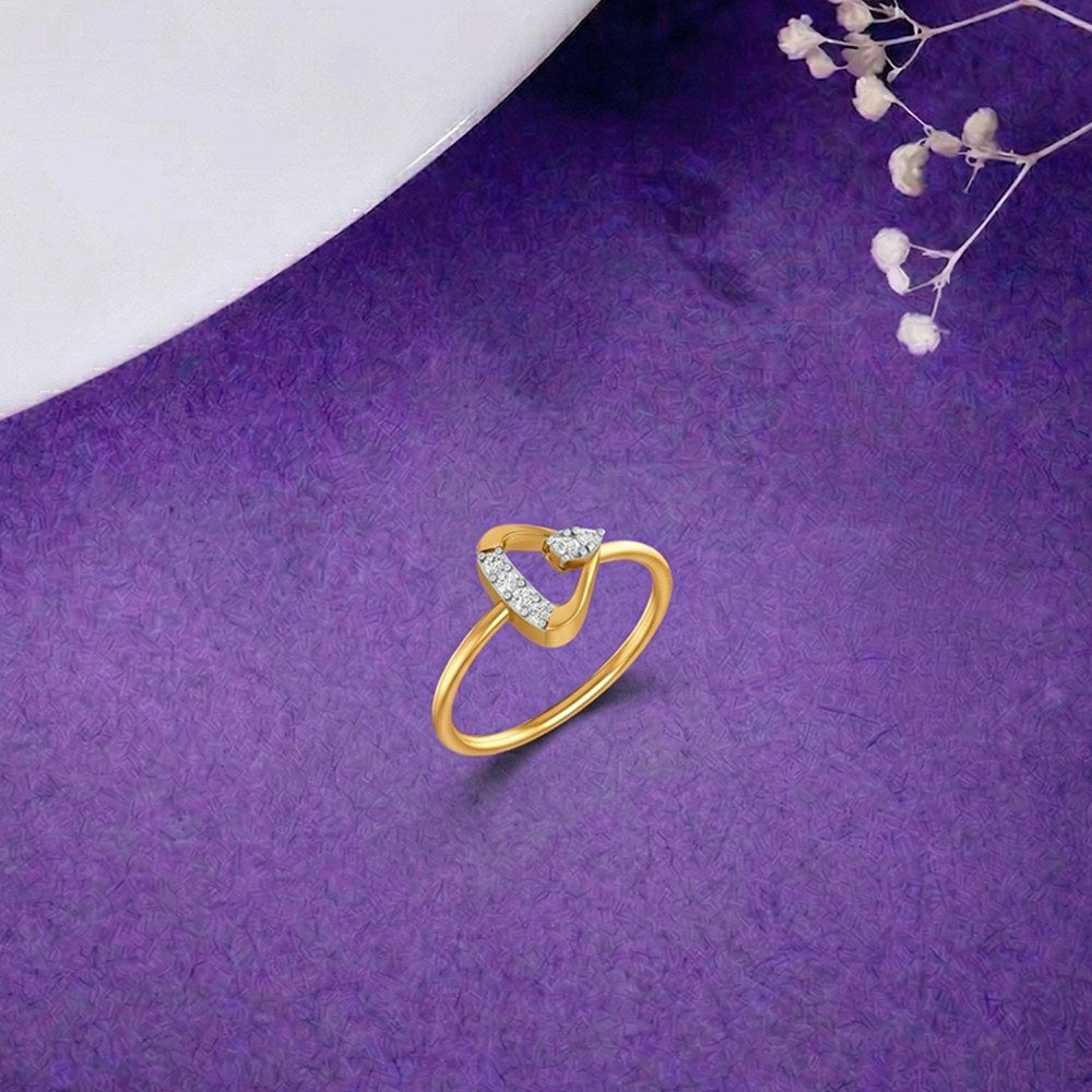 A gold and diamond ring with a triangular open design, displayed on a textured purple surface.