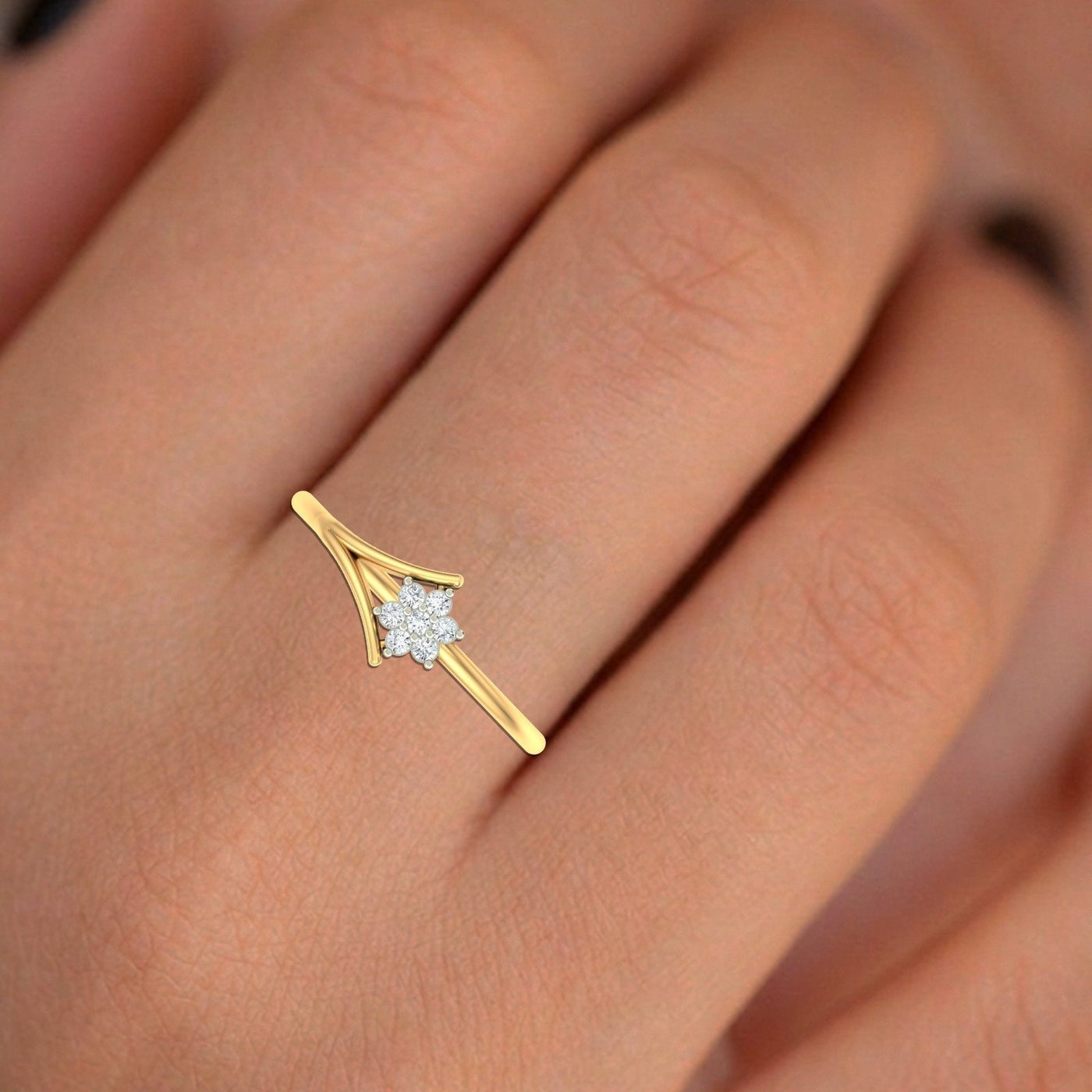 Gold and diamond with floral-design cluster setting on a person's finger.