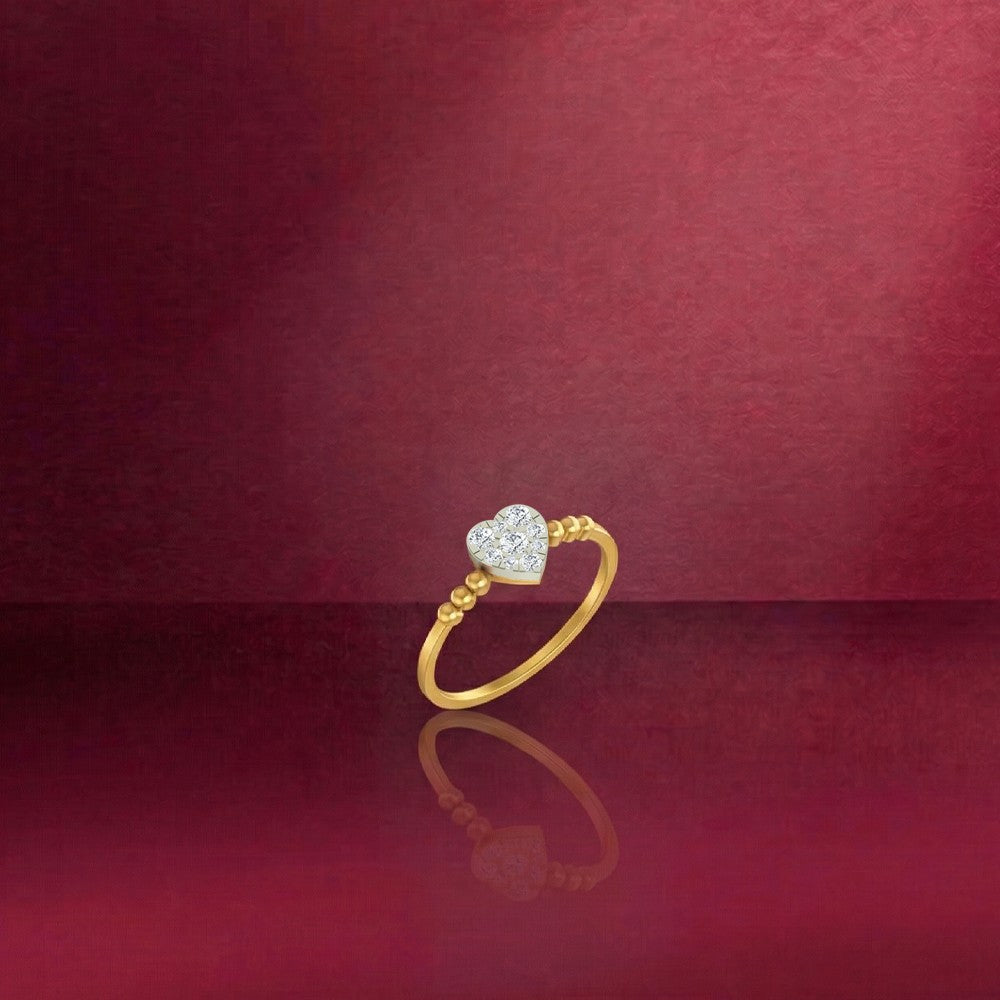 Gold and diamond with heart-shaped cluster setting on a red reflective surface.