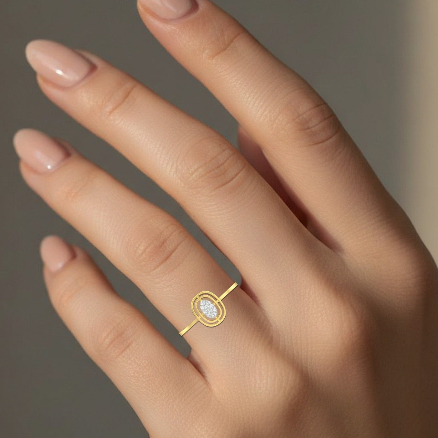 Gold ring with a diamond on a hand against a neutral background