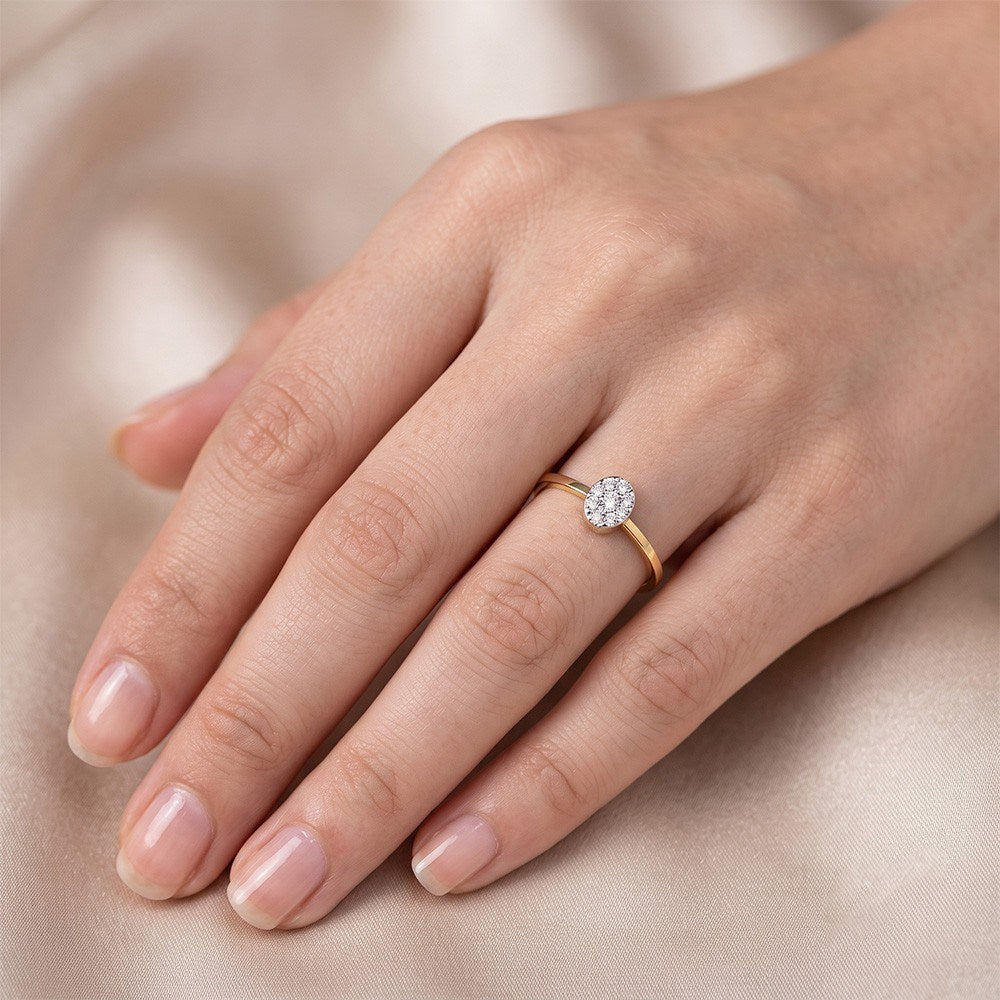 Gold and diamond with round-shaped cluster setting on a person's ring.
