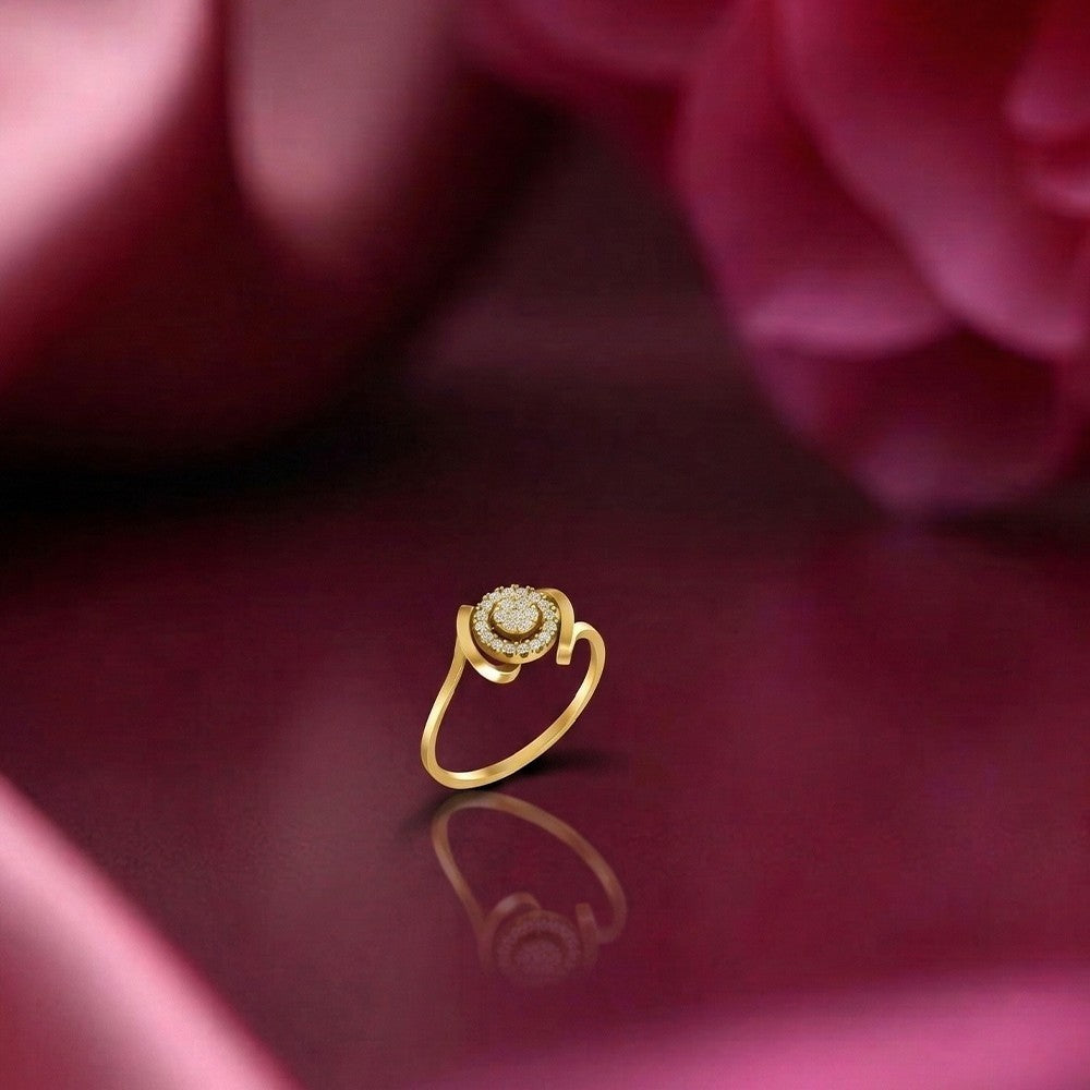 A gold ring with a round-cut cluster setting, displayed on a reflective dark pink surface.