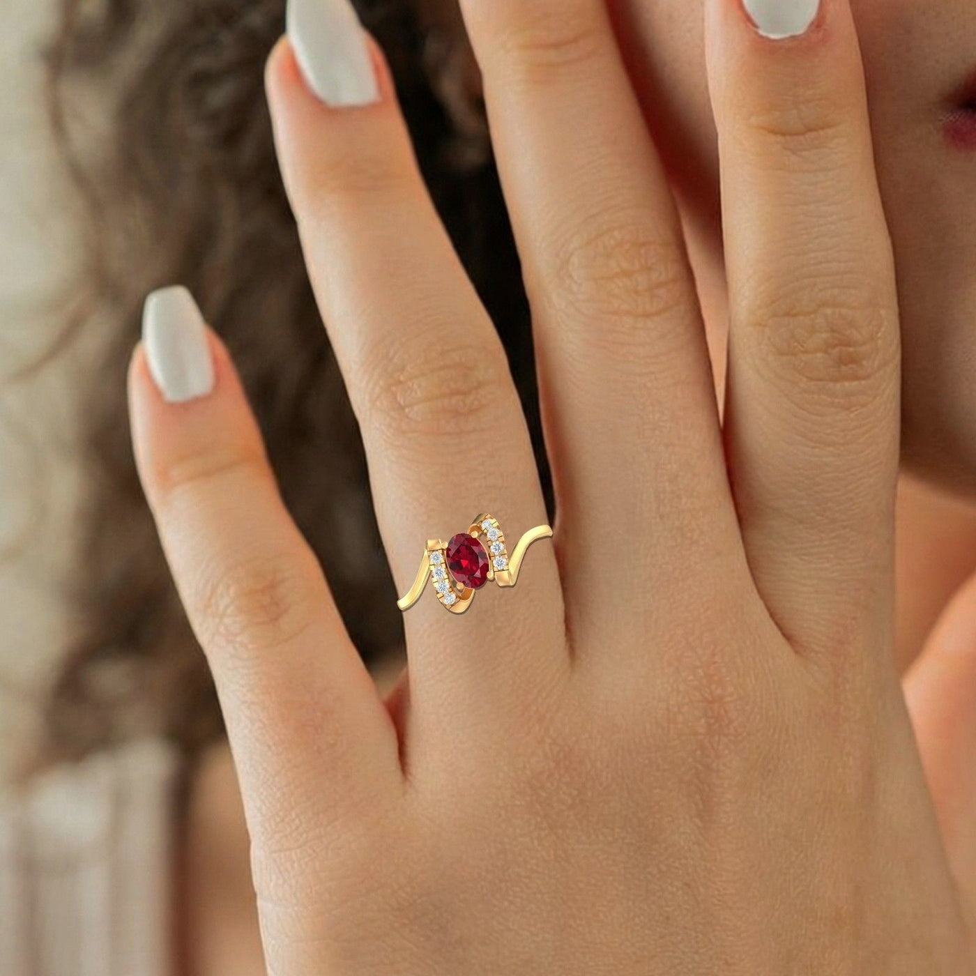 Close-up shot of a gold and diamond with oval ruby gemstone setting ring