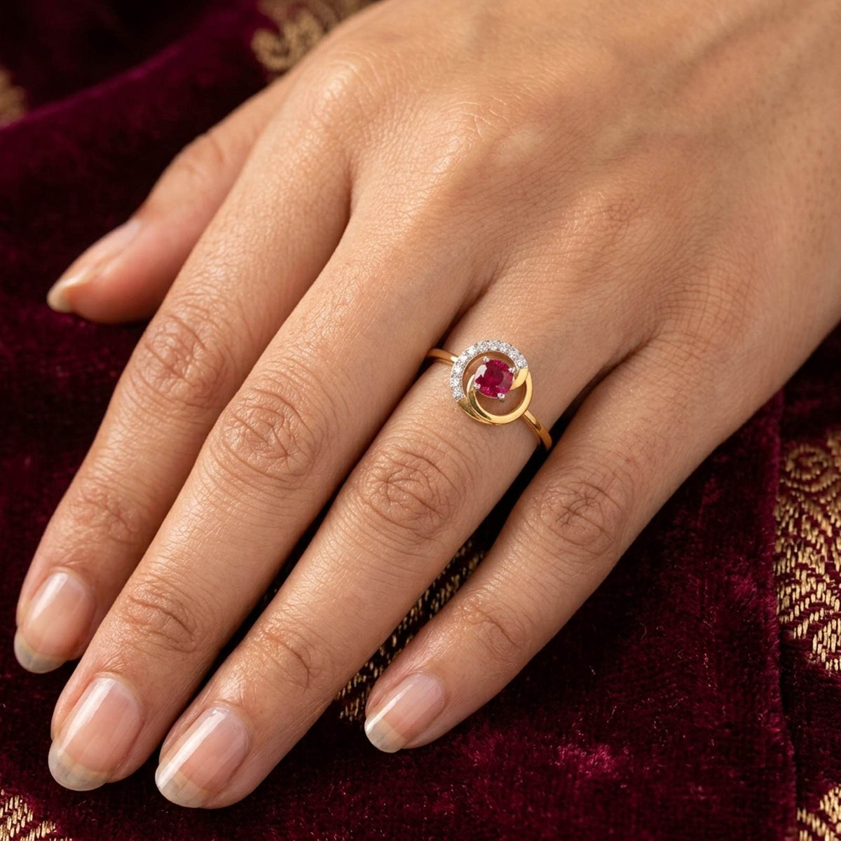 Gold and diamond with ruby gemstone on a person's finger.
