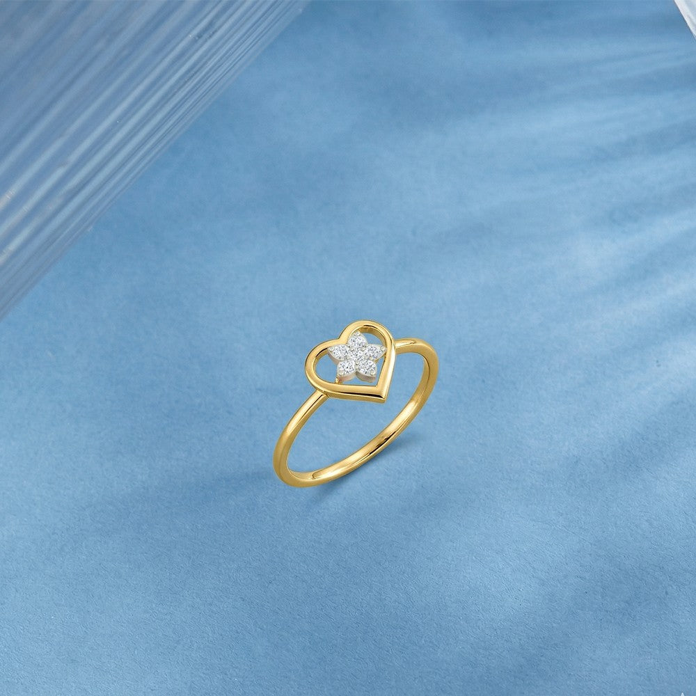 Gold and diamond with heart-shaped and floral cluster setting on a blue surface.
