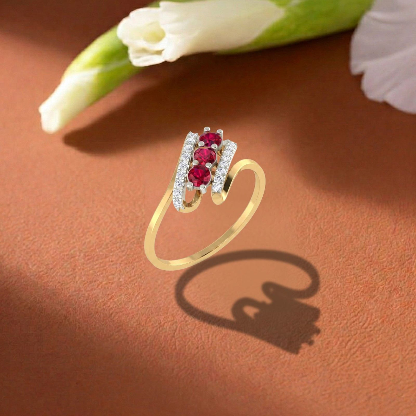 Gold and diamond with ruby gemstone on a light brown surface.