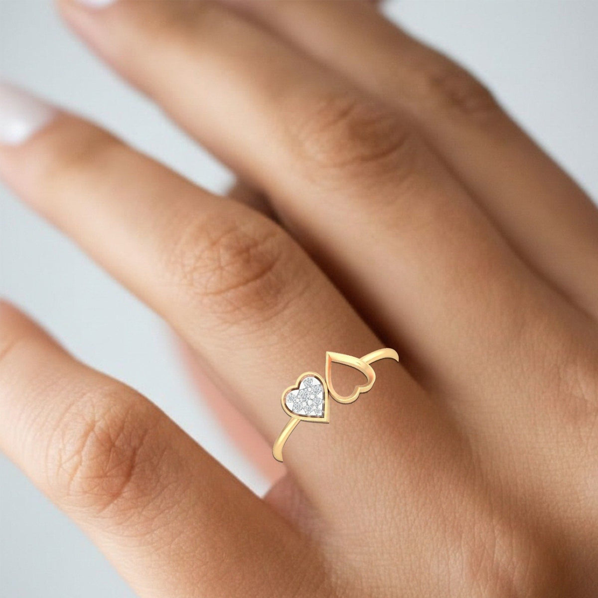 Gold and diamond with heart-shaped cluster setting on a person's finger.