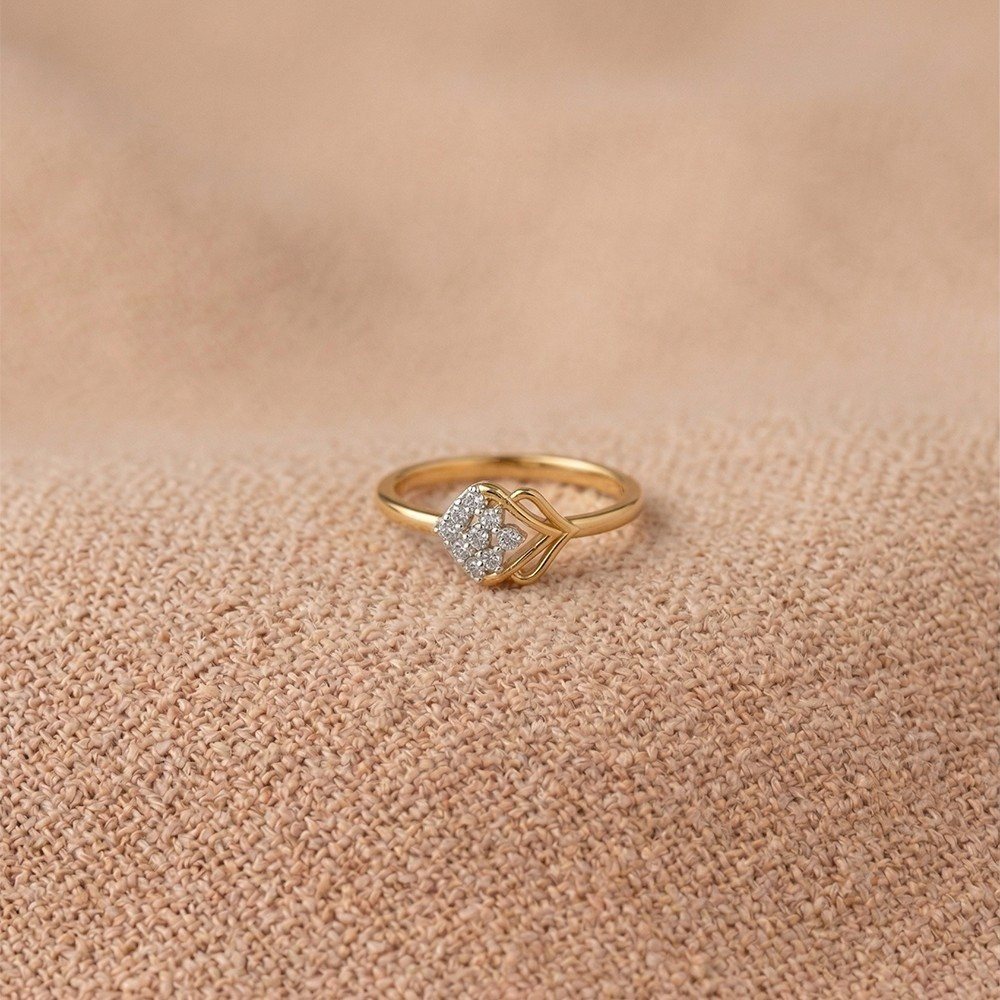 Gold and diamond with cluster setting on a texture fabric surface.
