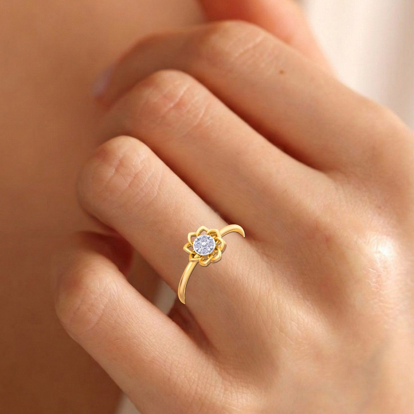 Gold and diamond with floral design on a hand.