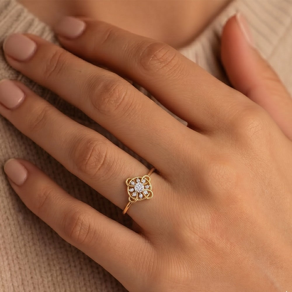 Gold ring with a diamond on a hand against a neutral background