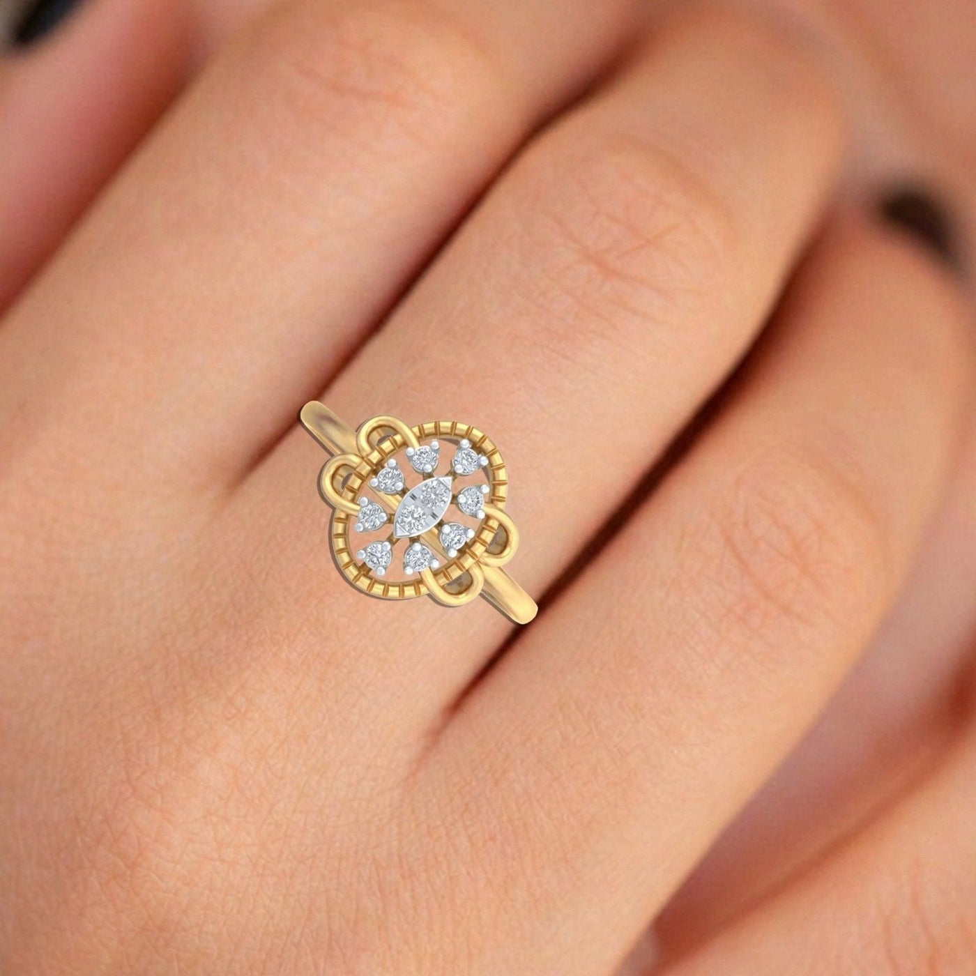 A gold ring with a floral-shaped pavé diamond setting, shown worn on a person's finger.