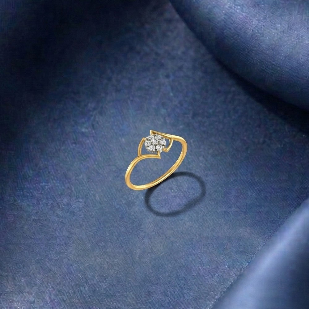 Gold ring with floral diamonds on a blue textured surface.
