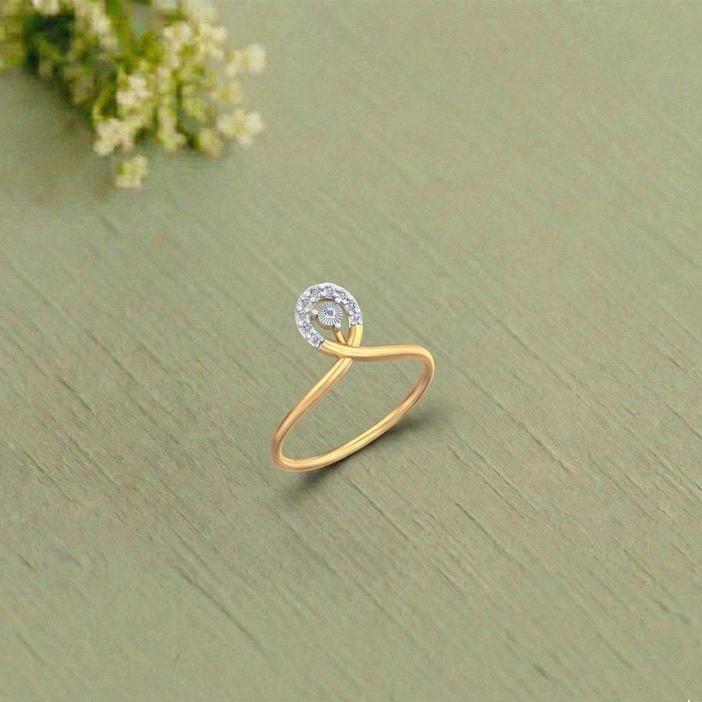 Gold and diamond women's ring on a saga green surface.