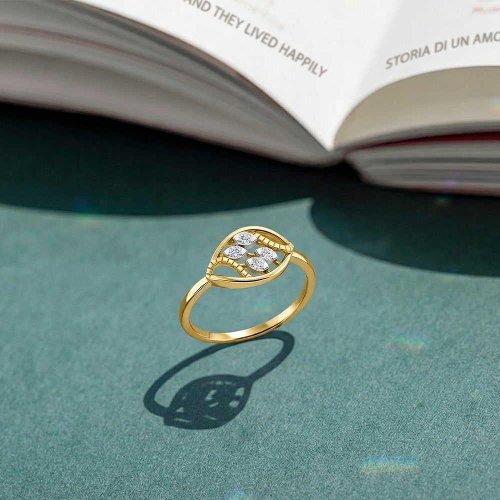 Gold and diamond women's ring on a green surface.