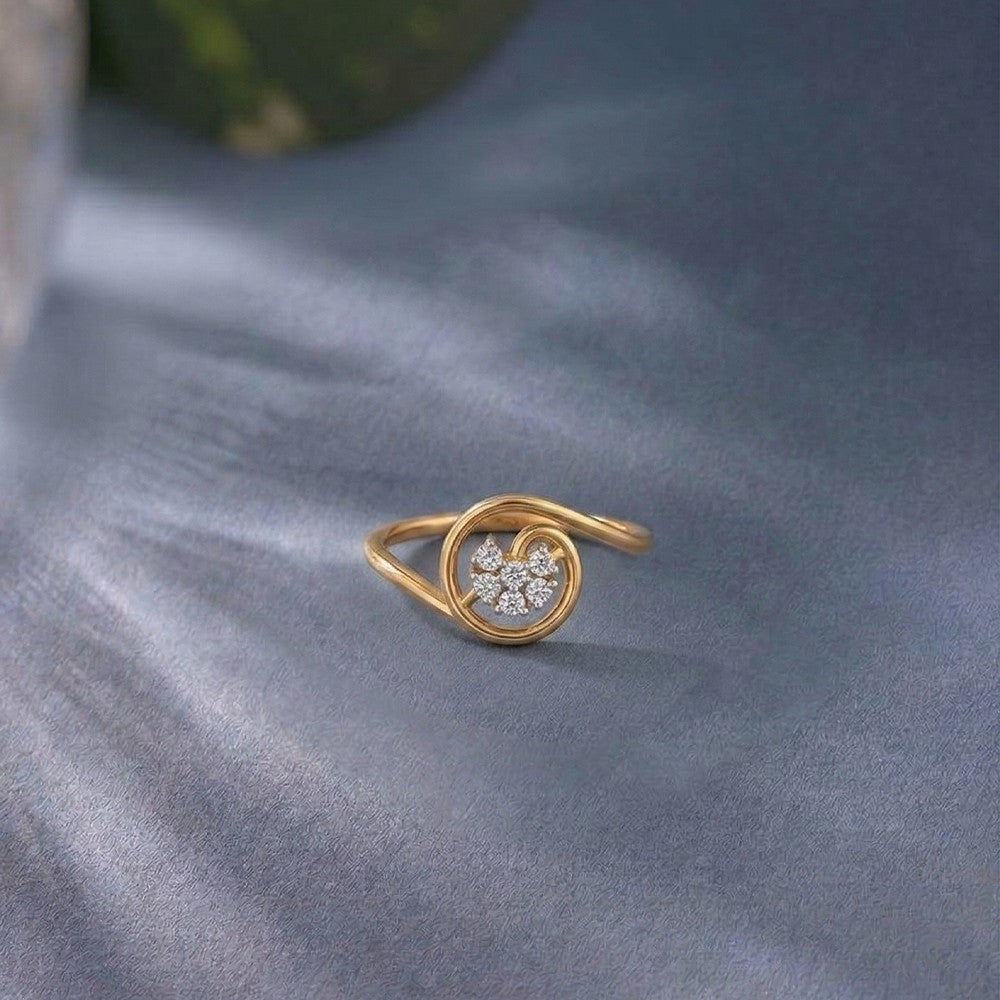 Gold ring with a floral-shaped diamond design on a gray fabric background