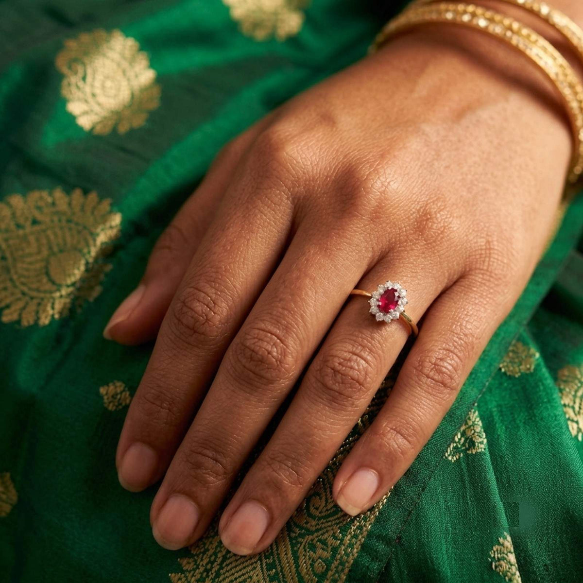 Close-up shot of a gold and diamond with oval-shaped ruby gemstone setting ring.