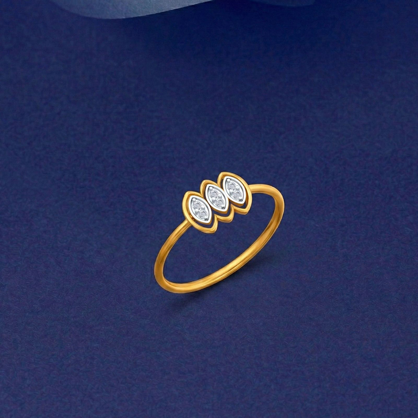 Gold and diamond ring featuring three marquise-cut diamond clusters, shown on a blue surface.
