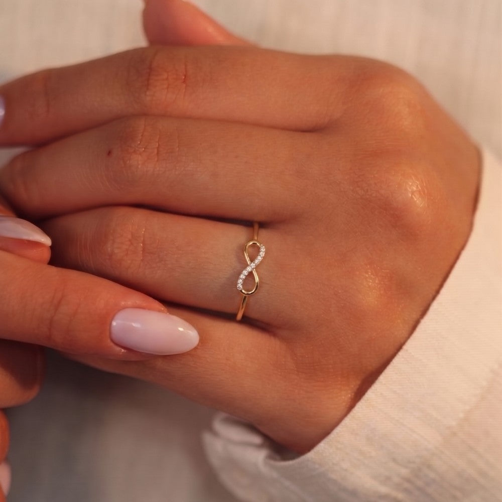 Close-up shot of a gold and dimaond with infinity design ring.