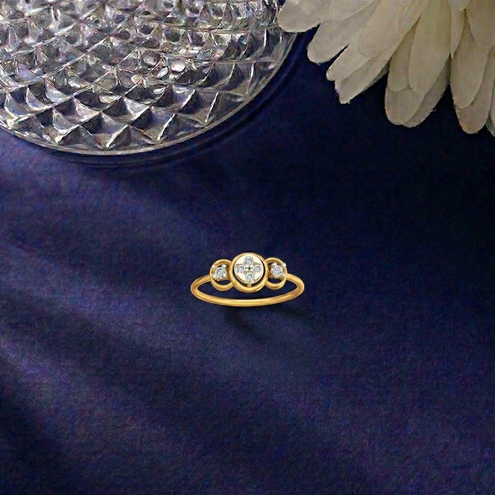Gold ring with diamonds on a dark blue fabric background