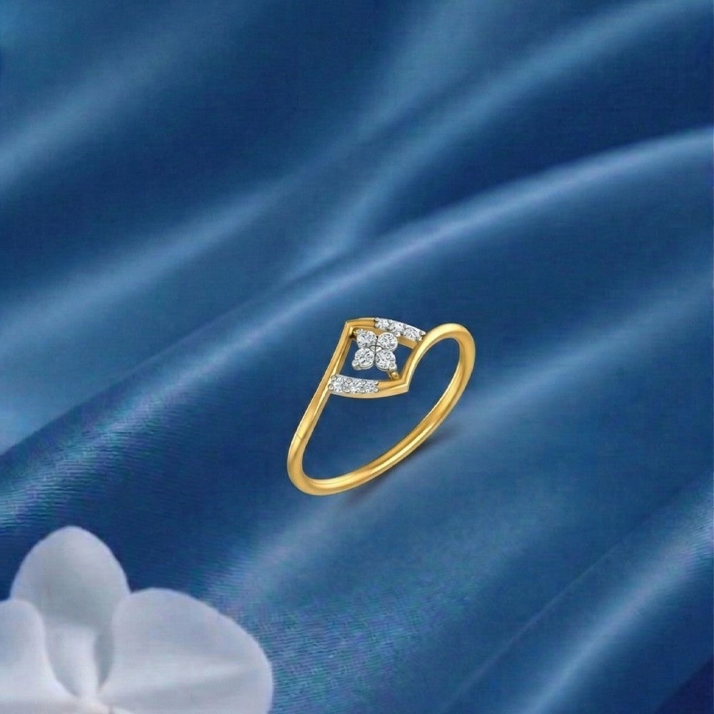 Gold ring with diamond accents on a blue fabric surface.